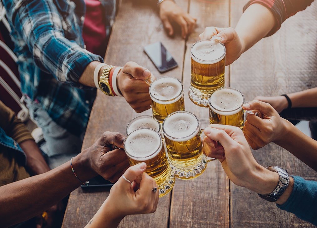 hands holding mugs cheersing in middle of table