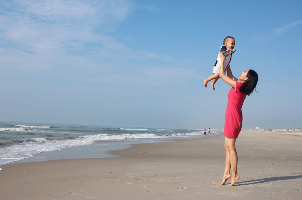 Picture of mother holding a baby on the beach.