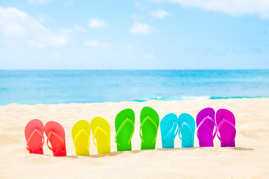 Spring Rainbow of colors in flip flops on sand